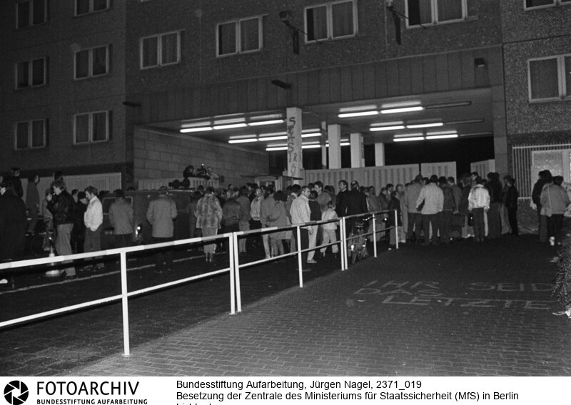 Tausende Menschen versammelten sich am 15.01.1990 vor der Zentrale des Ministeriums für Staatssicherheit (MfS) in Berlin Lichtenberg. Sie folgten damit dem Aufruf der Bürgerbewegung "Neues Forum". <BR>Aufnahmedatum: 15.01.1990<BR>Material/Technik: Foto<BR>Aufnahmeort: Berlin<BR>Signatur: 2371_019<BR>