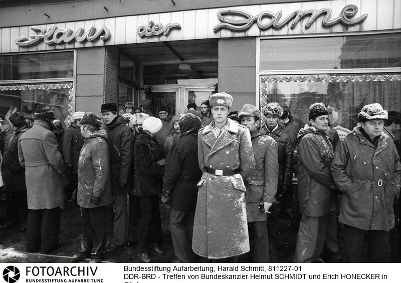 Polizisten und Staatssicherheitsleuten lassen nur ausgesuchte Personen auf den Marktplatz.<BR>Aufnahmedatum: Dezember 1981<BR>Material/Technik: Foto<BR>Aufnahmeort: Güstrow / DDR (Deutschland)<BR>Signatur: 811227-01