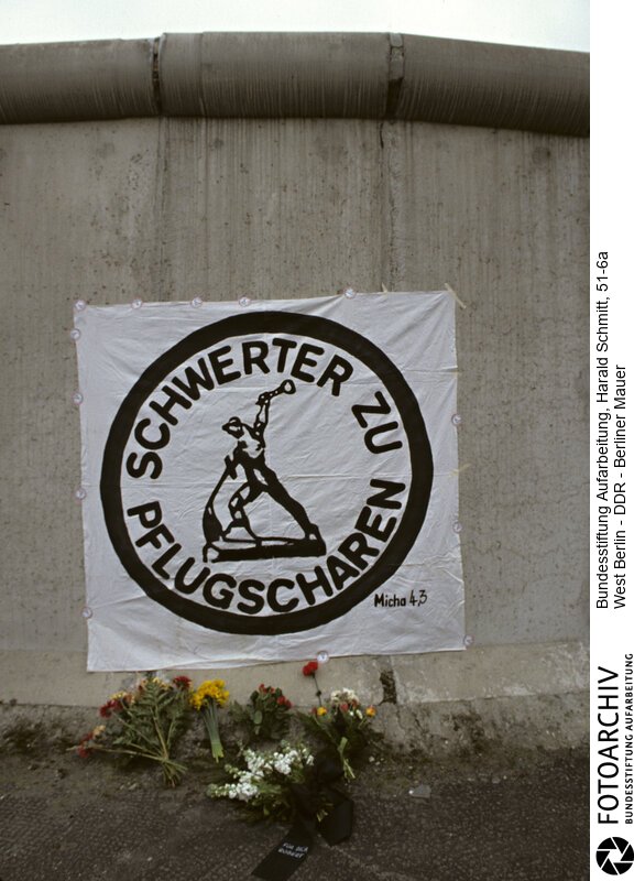 Auf der Westseite hängt ein Plakat "Schwerter zu Flugscharen"; am Tag der Beisetzung von Robert Havemann. Dia 51/6<BR>Person: Havemann, Robert, [11.03.1910 - 09.04.1982], deutscher Regimekritiker der DDR<BR>Aufnahmedatum: Mai 1982<BR>Material/Technik: Foto / Dia<BR>Aufnahmeort: Berlin / BRD (Deutschland)<BR>Signatur: 51-6a