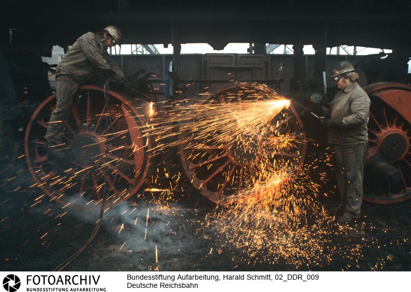 Im Bahnhof Meiningen zerlegen Arbeiter eine 44er Lokomotive. Dia: 33/03<BR>Aufnahmedatum: September 1982<BR>Material/Technik: Foto / Dia<BR>Aufnahmeort: Meiningen / DDR (Deutschland)<BR>Signatur: 02_DDR_009