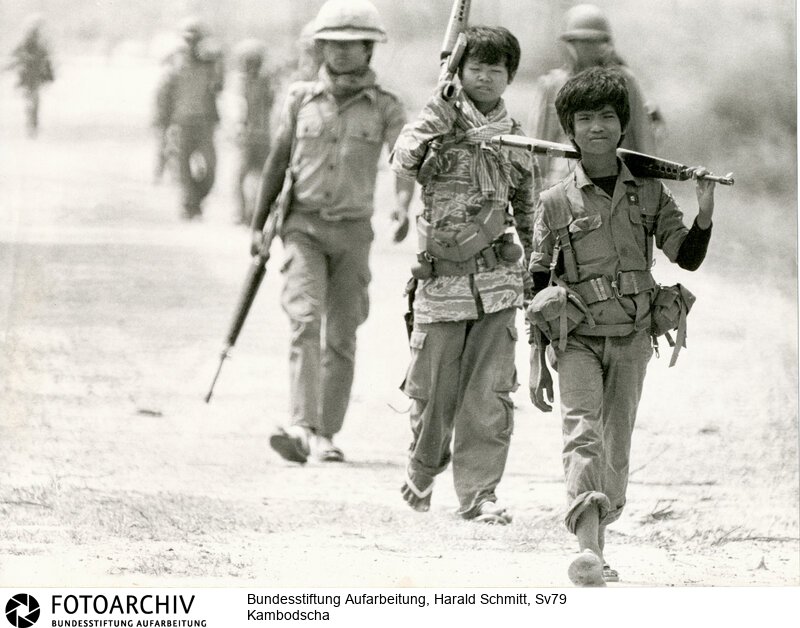 Letzter Ansturm auf PNOM PENH - Die Streitkräfte der Roten Khmer haben die Hauptstadt Pnom Penh von drei Seiten eingekesselt. Die Stadt wird bald fallen. Sie setzen Granatwerfer ein, die eine grössere Genauigkeit als Geschütze haben. Die Regierungstruppen benötigen jeden, der eine Waffe halten kann, auch wenn sie noch Kinder sind. <BR>Aufnahmedatum: April 1975<BR>Material/Technik: Foto<BR>Aufnahmeort: Pnom Penh / Kambodscha<BR>Signatur: Sv79