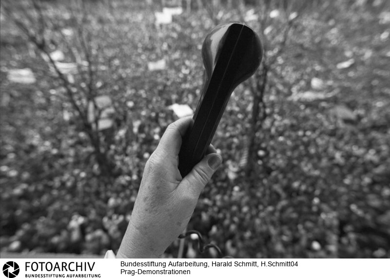 Demonstrationen in Prag in der Tschechoslowakei vom 21.-25.11.1989. Grossdemonstration auf dem Wenzelsplatz mit über 200 000 Menschen.  Die Sekretärin Jaromira SAFRANKOVA hält einen Telefonhörer hoch, damit ihre Verwandten in der Provinz erfahren was in der Hauptstadt los ist. Film: 89 1107  Negativ: 31.<BR>Aufnahmedatum: November 1989<BR>Material/Technik: Foto<BR>Aufnahmeort: Prag / Tschechoslowakei (Tschechien)<BR>Signatur: H.Schmitt04