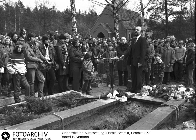 Beisetzung des DDR Regimekritikers Prof. Robert HAVEMANN in Grünheide. Am Grab: der Pfarrer der Erlöserkirche Rainer EPPELMANN. Film: 82 0438  Negativ: 9<BR>Person: Havemann, Robert, [11.03.1910 - 09.04.1982], deutscher Regimekritiker der DDR Eppelmann, Rainer, [12.2.1943 -], deutscher evangelischer Pfarrer, Bürgerrechtler und seit 1998 Vorstandsvorsitzender der Bundesstiftung zur Aufarbeitung der SED-Diktatur<BR>Aufnahmedatum: 1982<BR>Material/Technik: Foto<BR>Aufnahmeort: Grünheide (Mark) / DDR (Deutschland)<BR>Signatur: Schmitt_353