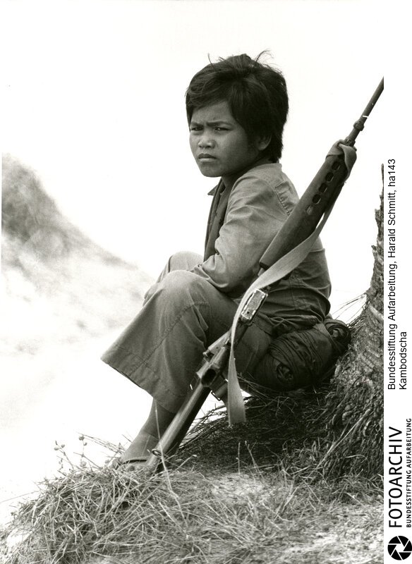 Letzter Ansturm auf PNOM PENH - Die Streitkräfte der Roten Khmer haben die Hauptstadt Pnom Penh von drei Seiten eingekesselt. Die Stadt wird bald fallen. Sie setzen Granatwerfer ein, die eine grössere Genauigkeit als Geschütze haben. Die Regierungstruppen benötigen jeden, der eine Waffe halten kann, auch wenn sie noch Kinder sind. <BR>Aufnahmedatum: April 1975<BR>Material/Technik: Foto<BR>Aufnahmeort: Pnom Penh / Kambodscha<BR>Signatur: ha143