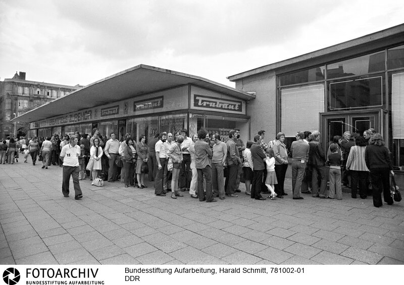 Menschenschlange vor einem Autohandel in Ost-Berlin, welcher an diesem Tage Auspuffanlagen verkauft.<BR>Aufnahmedatum: 1978<BR>Material/Technik: Foto<BR>Aufnahmeort: Berlin / DDR (Deutschland)<BR>Signatur: 781002-01