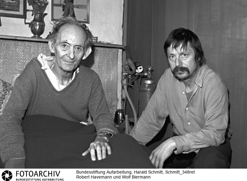 DDR - Der Sänger Wolf BIERMANN besucht den todkranken Regimekritiker Robert HAVEMANN an dessen Bett in seinem Haus in Grünheide bei Berlin. Die DDR Behörden haben Gnade vor Recht ergehen lassen und haben Biermann, heimlich, die Einreise gestattet. Film: 82 0401  Negativ: 4<BR>Person: Biermann, Wolf, [15.11.1936 - ], deutscher Liedermacher und Lyriker Havemann, Robert, [11.03.1910 - 09.04.1982], deutscher Regimekritiker der DDR<BR>Aufnahmedatum: 1982<BR>Material/Technik: Foto<BR>Aufnahmeort: Grünheide (Mark) / DDR (Deutschland)<BR>Signatur: Schmitt_348ret