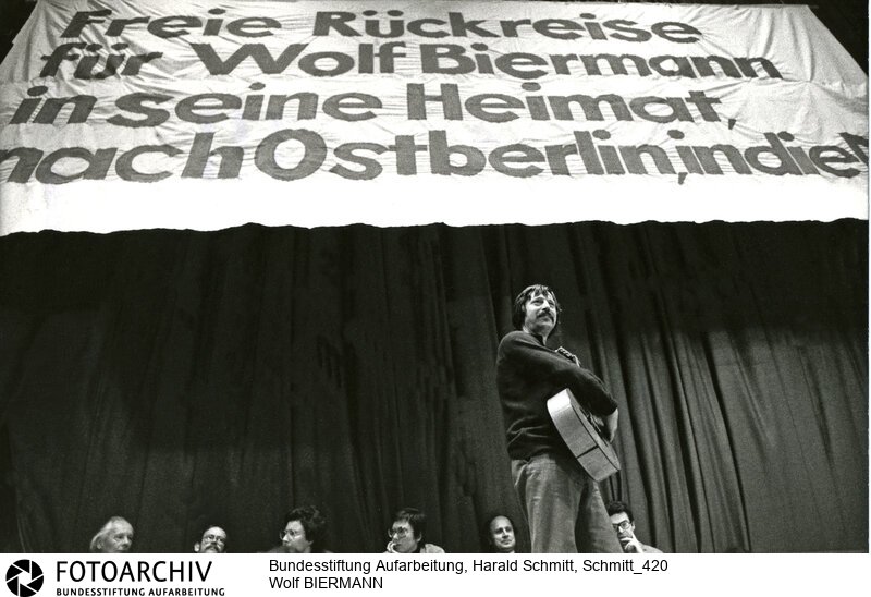 Wolf Biermann, aus der DDR abgeschobener Liedermacher (Mitte) bei einem Konzert in Bochum. <BR>Person: Biermann, Wolf, [15.11.1936], deutscher Liedermacher und Lyriker<BR>Aufnahmedatum: 1976<BR>Material/Technik: Foto<BR>Aufnahmeort: Bochum / BRD (Deutschland)<BR>Signatur: Schmitt_420