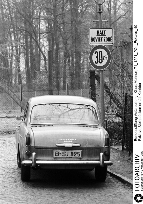 Foto: Anwohnerparkplatz vor der Mauer um die Exklave. Berlin (Berlin West), 21. 12. 1971. Nach dem gestern geschlossenem Abkommen besuchten Politiker und US-Militär per Hubschrauber die Einwohner der Exklave. Die DDR wird einen 20 Meter breiten Geländestreifen auf gut einem Kilometer abtreten. Der Senat baut darauf eine Straße, die das Eremitendasein der Bewohner beendet.<BR>Material/Technik: Foto<BR>Berlin (West)<BR>Signatur: 71_1221_POL_Exklave_40