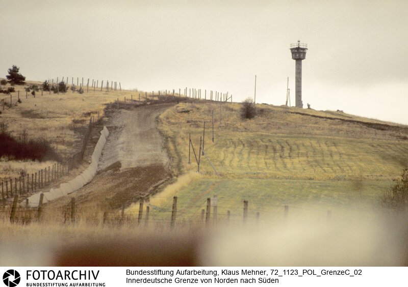 Landkreis Göttingen (Niedersachsen), 23. 11. 1972. Seit dem Bau der Mauer hat die Deutsche Demokratische Republik (DDR) die Demarkationslinie entlang ihrer Staatsgrenze West optimiert. Die dem Gelände angepasste Zonengrenze zementiert die Teilung Deutschlands, für Flüchtlinge besteht Lebensgefahr. Das durch Grenzsoldaten bewachte Sperrsystem ist durch Minen, Todesstreifen und Wachtürme abgeriegelt. Foto: Sperrsystem mit geräumtem Schussfeld bei Gut Besenhausen. East German border near Besenhausen.<BR>Material/Technik: Foto<BR>Niedersachen<BR>Signatur: 72_1123_POL_GrenzeC_02