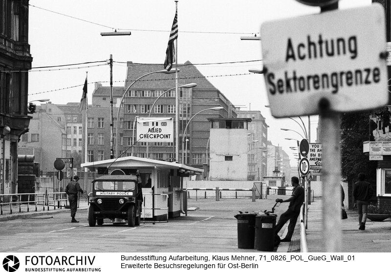 Foto: Innerstädtischer Grenzübergang Checkpoint Charlie für Ausländer. Berlin (Berlin West), 26. 08. 1971. Im Schlepp des Berlin-Abkommens kommt es wieder zu innerdeutschen Gesprächen. Angestrebt werden touristische Einreisen für jeden West-Berliner in den Ostteil und ein vereinfachter Transitverkehr nach Westdeutschland.<BR>Material/Technik: Foto<BR>Berlin (West)<BR>Signatur: 71_0826_POL_GueG_Wall_01