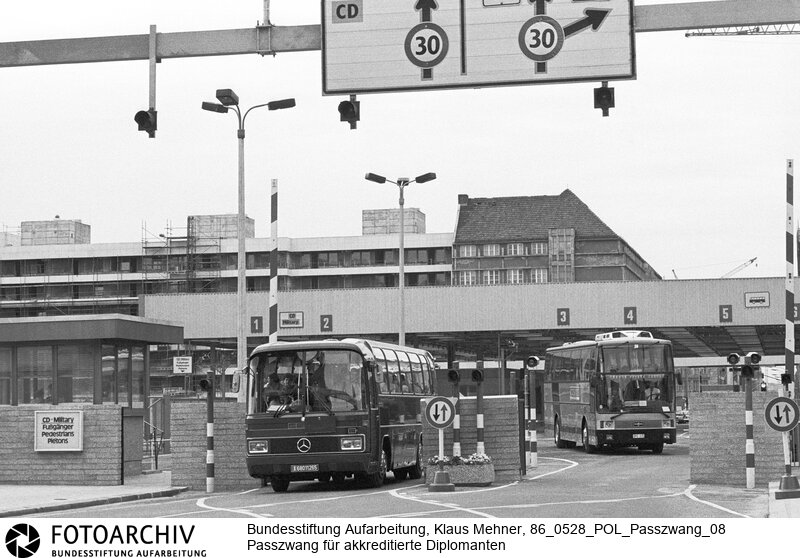 Diplomaten sollen sich ausweisen. Berlin (Berlin West) DDR, 28. 05. 1986. Foto: Bus der französischen Schutzmacht bei Rückkehr aus Ost-Berlin am Grenzübergang Checkpoint Charlie. Mit der für akkreditierte Diplomaten erlassenen Reisepassregelung versucht der Arbeiter- und Bauernstaat den Viermächtestatus auszuhebeln. Die Mauer wäre, bei Durchsetzung der Regelung, de facto Staatsgrenze. Die Westalliierten protestieren.<BR>Material/Technik: Foto<BR>Berlin (West)<BR>Signatur: 86_0528_POL_Passzwang_08