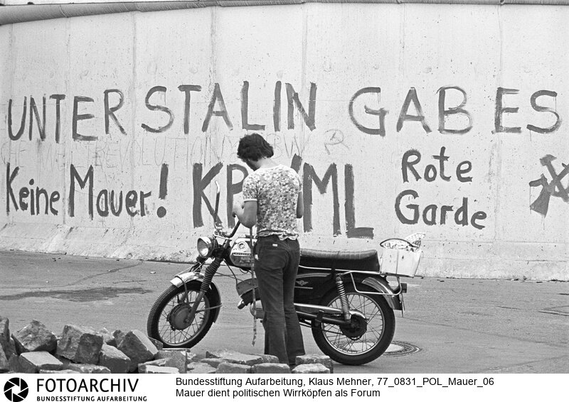 Berlin (Berlin West), 31-08-1977. Links- und rechtsradikale Parolen an der Mauer. Der nach Lesart der Deutschen Demokratischen Republik (DDR) antifaschistische Schutzwall dient politischen Wirrköpfen aller Schattierungen als Forum für ihre Parolen. Foto: Politische Parolen an der Mauer im Bezirk Kreuzberg.<BR>Material/Technik: Foto<BR>Berlin (West)<BR>Signatur: 77_0831_POL_Mauer_06