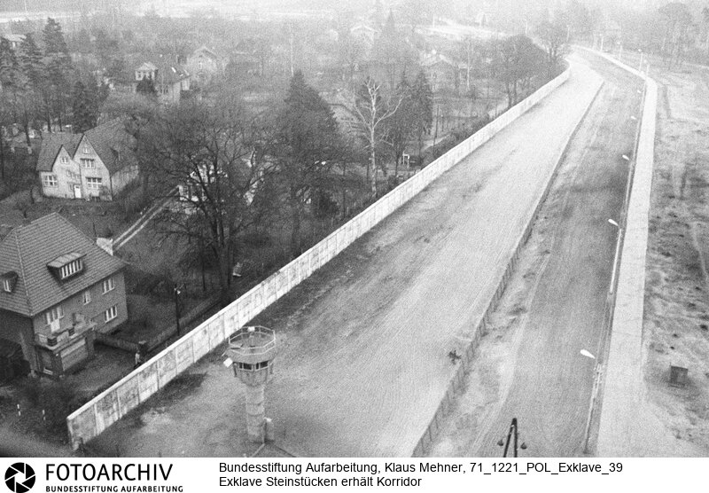 Foto: Luftaufnahme der Mauer um die Exklave. Berlin (Berlin West), 21. 12. 1971. Nach dem gestern geschlossenem Abkommen besuchten Politiker und US-Militär per Hubschrauber die Einwohner der Exklave. Die DDR wird einen 20 Meter breiten Geländestreifen auf gut einem Kilometer abtreten. Der Senat baut darauf eine Straße, die das Eremitendasein der Bewohner beendet.<BR>Material/Technik: Foto<BR>Berlin (West)<BR>Signatur: 71_1221_POL_Exklave_39