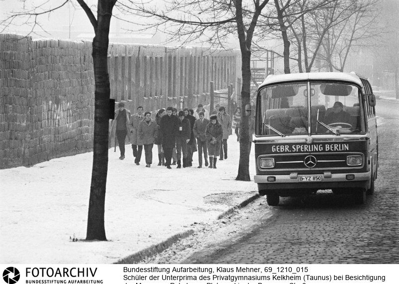 Mauertourismus westdeutscher Schulklassen. Das Ministerium für gesamtdeutsche Fragen subventioniert Klassenfahrten von Schulklassen aus der Bundesrepublik nach Berlin. Das Programm soll bei jungen Menschen das Verständnis für die so genannte offene deutsche Frage vertiefen.<BR>Aufnahmedatum: 10.12.1969<BR>Material/Technik: Fotografie<BR>Aufnahmeort: West-Berlin, BRD (Deutschland)<BR>Signatur: 69_1210_015<BR>
