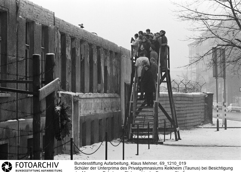 Mauertourismus westdeutscher Schulklassen. Das Ministerium für gesamtdeutsche Fragen subventioniert Klassenfahrten von Schulklassen aus der Bundesrepublik nach Berlin. Das Programm soll bei jungen Menschen das Verständnis für die so genannte offene deutsche Frage vertiefen.<BR>Aufnahmedatum: 10.12.1969<BR>Material/Technik: Fotografie<BR>Aufnahmeort: West-Berlin, BRD (Deutschland)<BR>Signatur: 69_1210_019<BR>