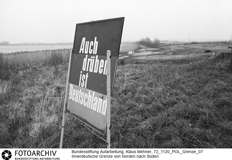 Landkreis Lauenburg (Schleswig-Holstein), 20. 11. 1972. Seit dem Bau der Mauer hat die Deutsche Demokratische Republik (DDR) die Demarkationslinie entlang ihrer Staatsgrenze West optimiert. Die Geländeanpassung der Zonengrenze zementiert die Teilung Deutschlands, für Flüchtlinge besteht Lebensgefahr. Das durch Grenzsoldaten bewachte Sperrsystem ist durch Todesstreifen, Minen und Wachtürme abgeriegelt. Foto: Kampagne des Kuratoriums unteilbares Deutschland an der innerdeutschen Grenze am Mechower See bei Wietingsbek (Ratzeburg). East-German Border at the banks of the Mechow lake naer Ratzeburg.<BR>Material/Technik: Foto<BR>Schleswig-Holstein<BR>Signatur: 72_1120_POL_Grenze_07