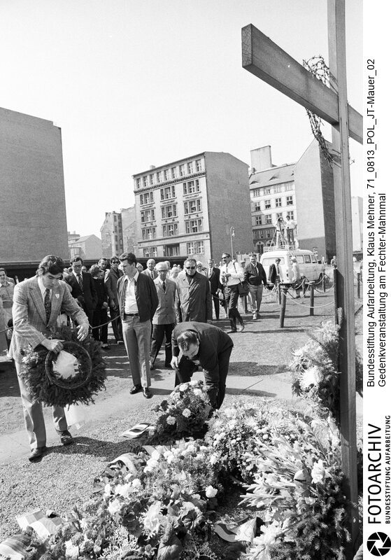 Foto: Teilnehmer bei Kranzniederlegung. Berlin (Berlin West), 13. 08. 1971. Wall of Shame. Gedenkveranstaltung am Peter Fechter Mahnmal zum zehnten (10.) Jahrestag des Mauerbaus. Teilnehmer waren neben der Arbeitsgemeinschaft 13. August die Aktion Oder Neiße (AKON) und andere Gruppen.<BR>Material/Technik: Foto<BR>Berlin (West)<BR>Signatur: 71_0813_POL_JT-Mauer_02