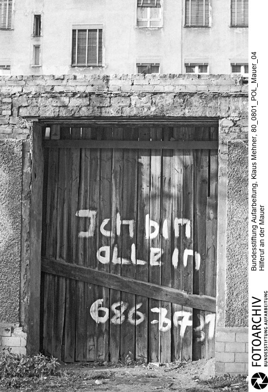 Foto: Hilferuf eines einsamen Menschen an der Mauer. Berlin (Berlin West), 01. 08. 1980. Der die Halbstadt teilende sogenannte Antifaschistische Schutzwall des Arbeiter- und Bauernstaates, vulgo Mauer, ist zur Projektionsfläche geworden. Im Bezirk Neukölln hinterließ jemand entlang der Mauer seine Botschaft.<BR>Material/Technik: Foto<BR>Berlin (West)<BR>Signatur: 80_0801_POL_Mauer_04
