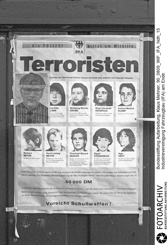 Nordhausen (Bezirk Erfurt) DDR, 09. 08. 1990. Katerstimmung im IFA Motorenwerk. Mit der Währungsunion brachen der Industrie der DDR (Deutsche Demokratische Republik) die Märkte weg. Die Mercedes-Benz AG kündigte das Joint Venture mit dem IFA Kombinat (Industrievereinigung Fahrzeugbau). Die Einstellung der Lkw-Baureihen W-50 und L-60 trifft die Zulieferer hart. Die IFA Motorenwerke GmbH hat die Produktion faktisch eingestellt und fährt an zwei Werktagen mit 3.000 Mitarbeitern Kurzarbeit. Foto: Erich Honecker auf modifiziertem RAF Fahndungsplakat auf dem Werksgelände.<BR>Material/Technik: Foto<BR>Bezirk Erfurt<BR>Signatur: 90_0809_WIF_IFA_Ndh_15