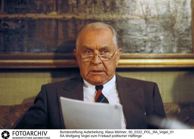 Berlin (Bezirk Berlin) DDR, 22. 03. 1990. Foto: Prof. Dr. Wolfgang Vogel (65) bei Interview in seinem Büro. Der Rechtsanwalt äußert sich zu Häftlingsfreikäufen und rechtfertigt sie mit dem humanitären Aspekt. In einem Gespräch mit dem Spiegel nahm der Beauftragte für humanitäre Fragen des Ex-Staatsratsvorsitzenden der DDR unter anderem zum Freikauf von politischen Häftlingen gegen Devisen durch die Bundesrepublik Stellung.<BR>Material/Technik: Foto<BR>Bezirk Berlin<BR>Signatur: 90_0322_POL_RA_Vogel_01
