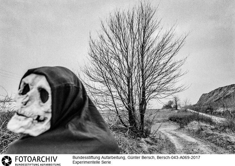 Experimentelle Fotografie und Reportage, Nachwende, Ostdeutschland, Niederröblingen, Halle, Sangerhausen, Helbra, Kreisfeld
(Anm. BPK: Hinter der Maske steckt der mit Bersch befreundete Fotograf Ulrich Burchert)<BR>Aufnahmedatum: 1992<BR>Material/Technik: Foto / s/w<BR>Aufnahmeort: Mansfelder Land (Sachsen-Anhalt), Deutschland<BR>Signatur: Bersch-043-A069-2017<BR>