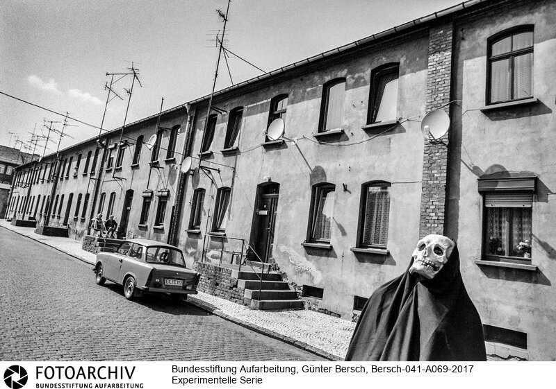 Experimentelle Fotografie und Reportage, Nachwende, Ostdeutschland, Niederröblingen, Halle, Sangerhausen, Helbra, Kreisfeld
(Anm. BPK: Hinter der Maske steckt der mit Bersch befreundete Fotograf Ulrich Burchert)<BR>Aufnahmedatum: 1992<BR>Material/Technik: Foto / s/w<BR>Aufnahmeort: Mansfelder Land (Sachsen-Anhalt), Deutschland<BR>Signatur: Bersch-041-A069-2017<BR>